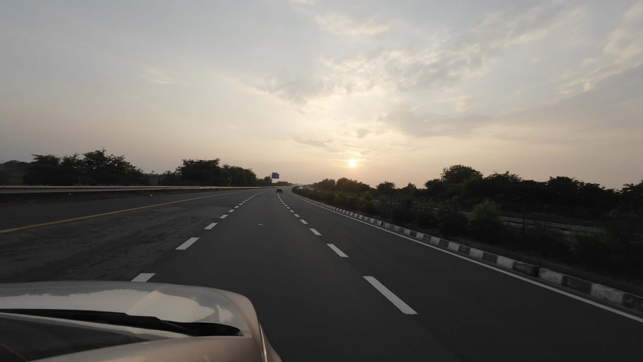 Smooth and well-maintained concrete lanes of the Agra-Lucknow Expressway stretching into the horizon during a road trip