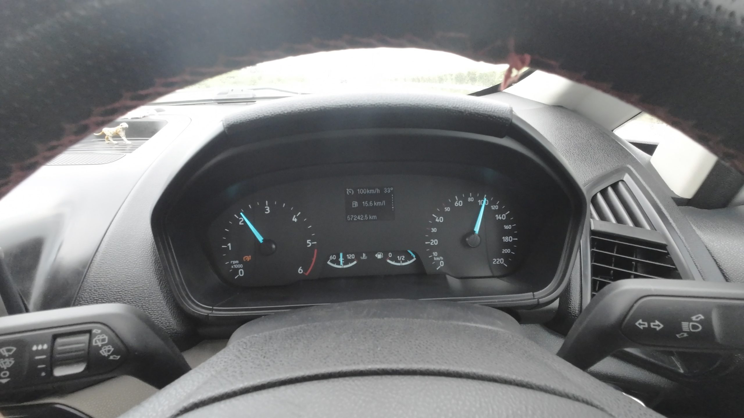 Car dashboard speedometer showing a steady 100 kmph speed while cruising on the Purvanchal Expressway for maximum fuel efficiency