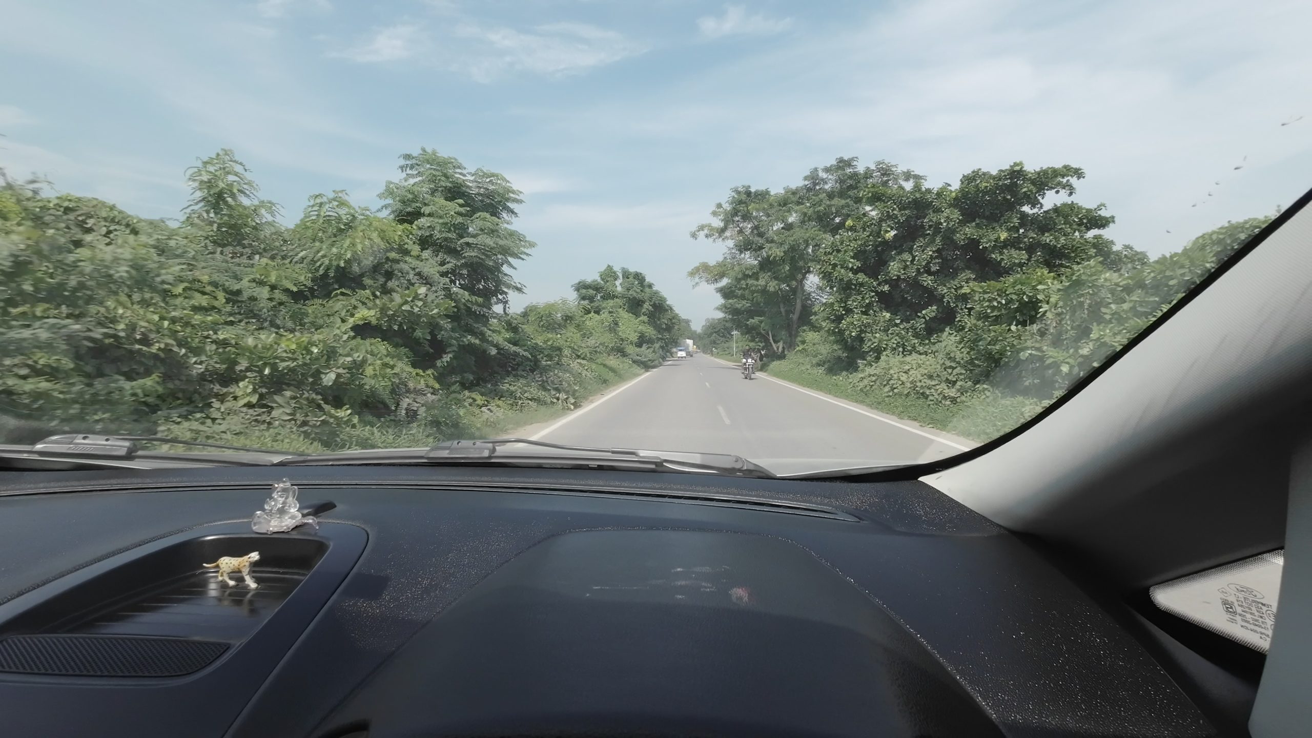 A narrow and bumpy 15 kilometer rural state connector road packed with local traffic leading toward the Purvanchal Expressway entry ramp in Uttar Pradesh
